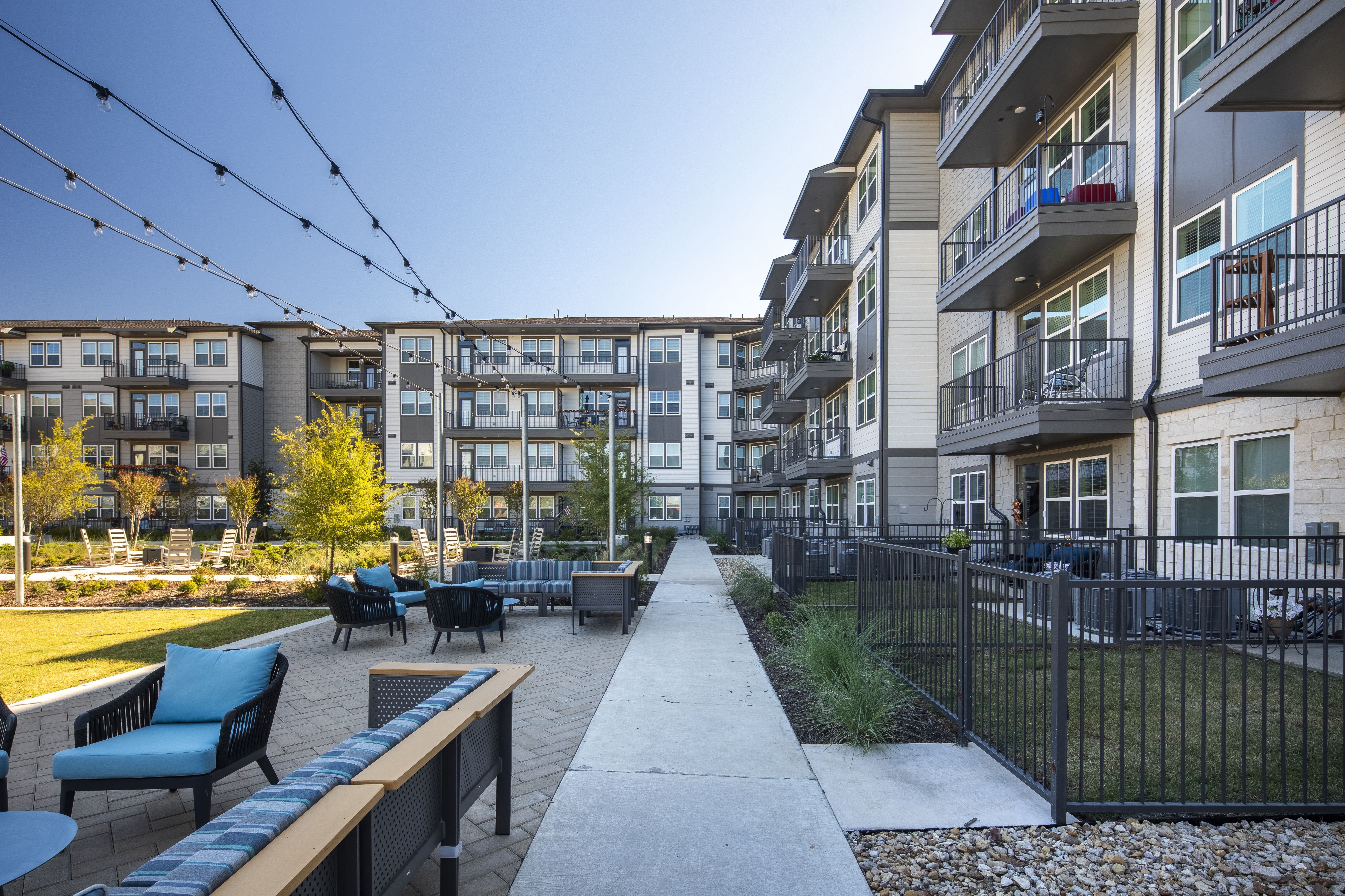 an outdoor patio area with tables and chairs at a senior apartment community